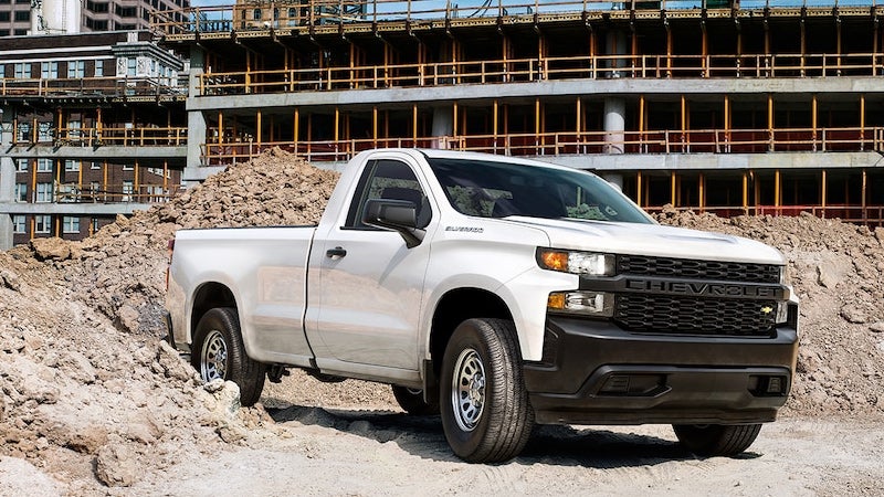 White Silverado parked at the construction site on dusty road